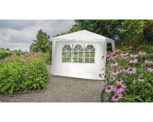 Tente de réception blanche avec fenêtres dans le jardin