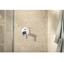 Robinet de douche apparent dans la salle de bains devant le carrelage mural