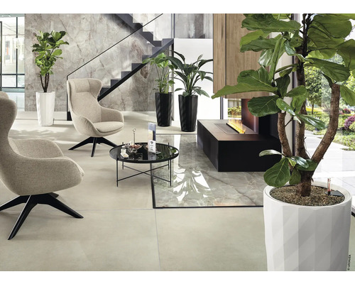 Intérieur moderne avec fauteuils, table, plantes et cheminée.