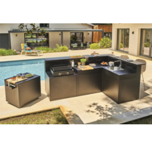 Outdoor-Küche neben einem Pool mit Grill, Spüle und Arbeitsflächen.