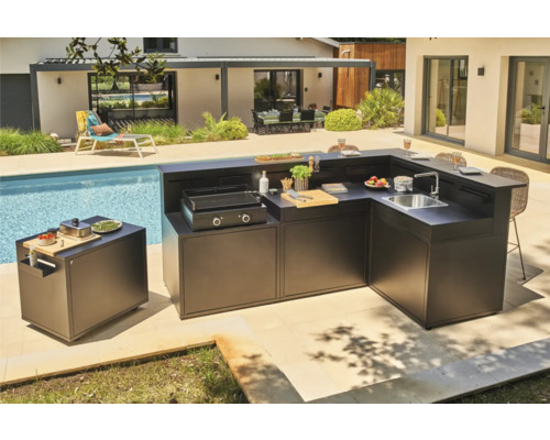 Outdoor-Küche neben einem Pool mit Grill, Spüle und Arbeitsflächen.