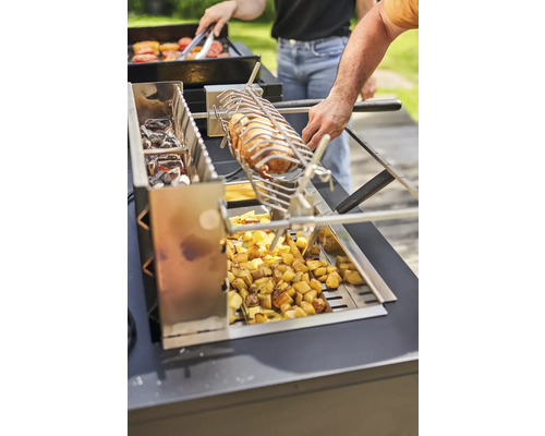 Holzkohlegrill mit Grillspiess, Grillgut und Kartoffeln