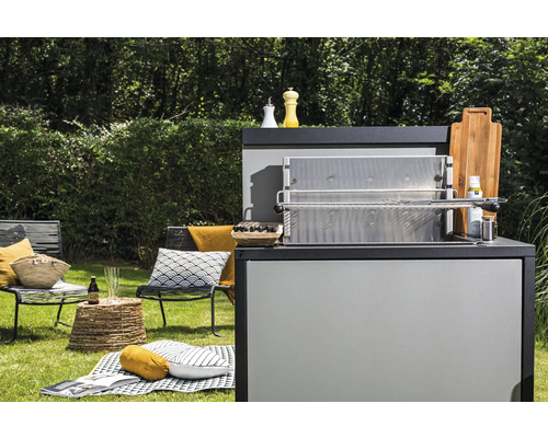Gartenszene mit Grillstation, Sitzgelegenheiten und Picknickdecke auf einer Rasenfläche
