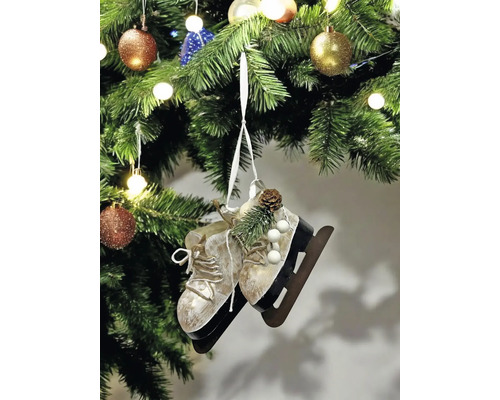 Dekorative Schlittschuhe als Christbaumschmuck an einem Weihnachtsbaum mit Kugeln und Lichtern.