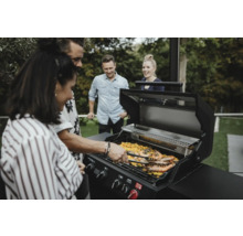 Gruppe von Personen grillt Garnelen auf einem Gasgrill im Freien