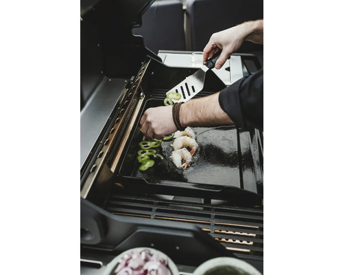 Des crevettes et des poivrons sont préparés sur un gril.