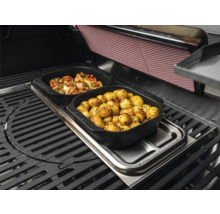 Barbecue avec des aliments dans des plats noirs : pommes de terre et fruits de mer.