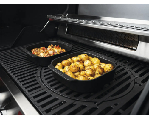 Deux plats à griller remplis de pommes de terre et de viande sur la grille du barbecue