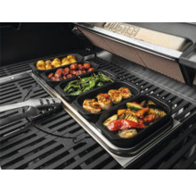 Divers plats grillés dans des récipients sur un barbecue