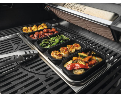 Divers plats grillés dans des récipients sur un barbecue