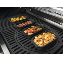 Divers plats dans des plats à griller sur un barbecue, y compris des pommes de terre, des rouleaux de viande, des légumes et des crevettes.