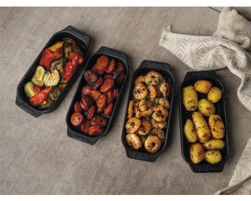 Quatre poêles de service noires contenant des légumes, de la saucisse, des crevettes et des pommes de terre