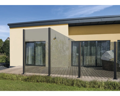 Terrasse mit Glaszaun und Holzboden vor einem Wohnhaus.