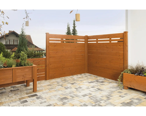 Clôture en bois avec jardinières sur une terrasse pavée