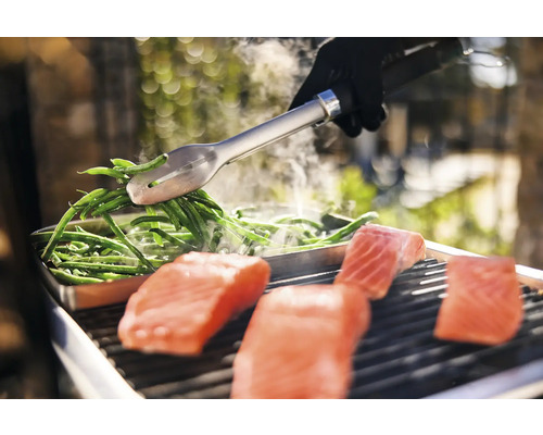 Préparation de saumon et de haricots verts sur le gril avec une pince de barbecue