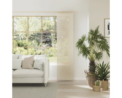 Salon lumineux avec rideau coulissant, canapé et plantes