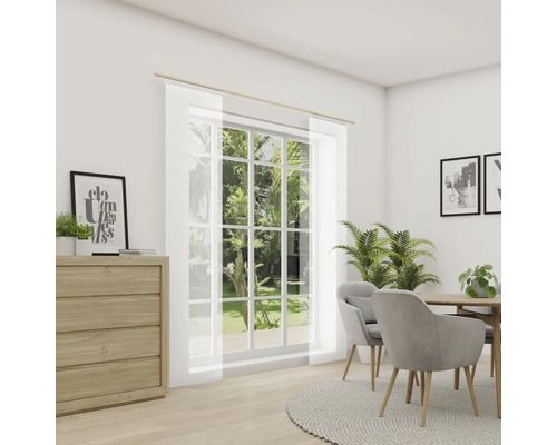 Salon avec commode, table à manger et rideaux coulissants transparents devant une fenêtre