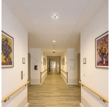Flur mit Deckenleuchten, Handlauf und Bildern