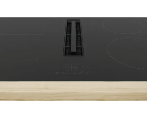 Table de cuisson noire avec hotte aspirante.