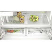 Intérieur d''un réfrigérateur avec des légumes, des fruits et de la salade dans des compartiments et des récipients