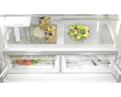 Intérieur d''un réfrigérateur avec des légumes, des fruits et de la salade dans des compartiments et des récipients