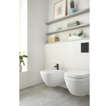 Salle de bains lumineuse avec bidet, toilettes et étagères
