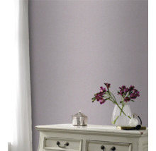 Pièce décorative avec papier peint à motifs sur le mur, commode, vase de fleurs et rideau à la fenêtre.