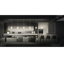 Moderne Küche mit Pendelleuchten über einer Kochinsel mit Barhockern