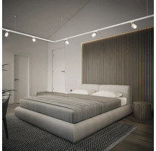 Chambre lumineuse avec lit double, lambris en bois et système de rail avec spots