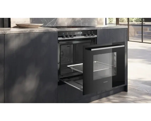 Four encastrable avec porte ouverte dans une cuisine moderne.