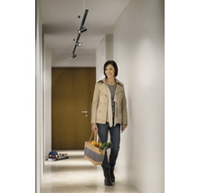 Flur mit moderner Deckenleuchte und einer Frau mit Einkaufstasche