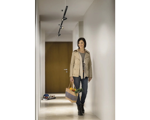 Flur mit moderner Deckenleuchte und einer Frau mit Einkaufstasche