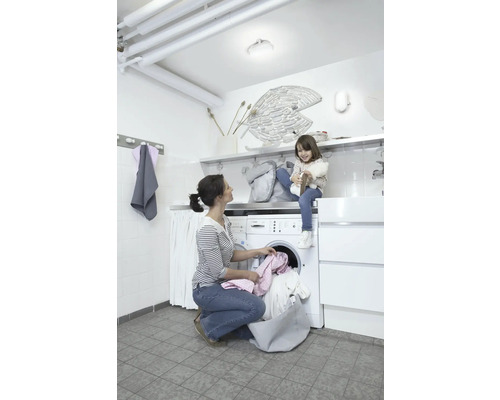 Waschküche mit Waschmaschine, Mutter und Kind bei der Hausarbeit