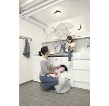 Frau und Kind im Waschraum mit Waschmaschine und Trockner.