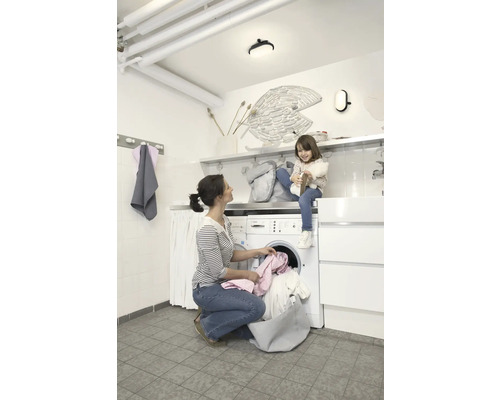 Frau und Kind im Waschraum mit Waschmaschine und Trockner.