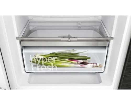 Bac à légumes dans un réfrigérateur avec des oignons nouveaux