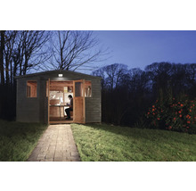 Gartenhaus bei Nacht mit Person am Schreibtisch