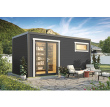 Abri de jardin avec porte vitrée et fenêtre, entouré de mobilier de jardin sur une terrasse en pierre