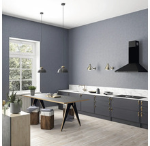 Vue d''une cuisine avec table à manger, tabourets, suspensions, appliques murales et hotte aspirante devant un mur gris