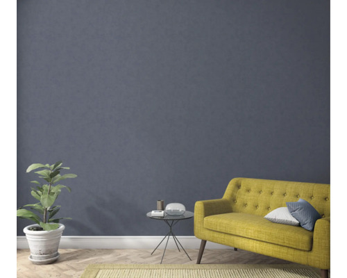 Salon avec un canapé jaune, une plante, une table et un tapis pour une ambiance chaleureuse