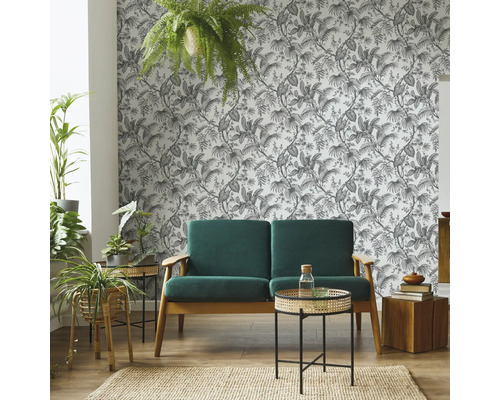 Salon avec canapé, tables d''appoint, plantes d''intérieur, tapis et papier peint à motifs