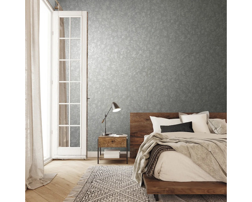 Chambre avec papier peint à motifs, lit en bois et lampe de chevet