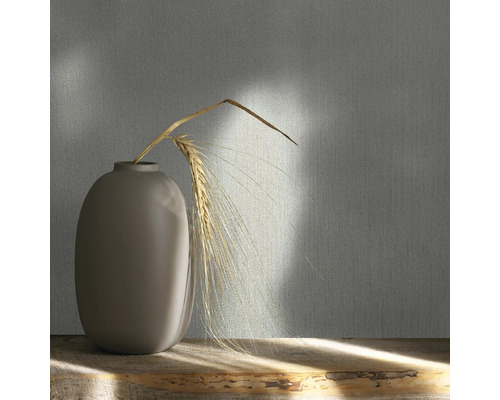 Papier peint décoratif avec motif textile et vase avec épi de blé sur une table en bois.