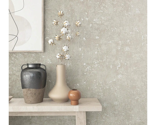 Gros plan d''une table décorée avec des vases, des branches de coton et une œuvre d''art sur un mur texturé