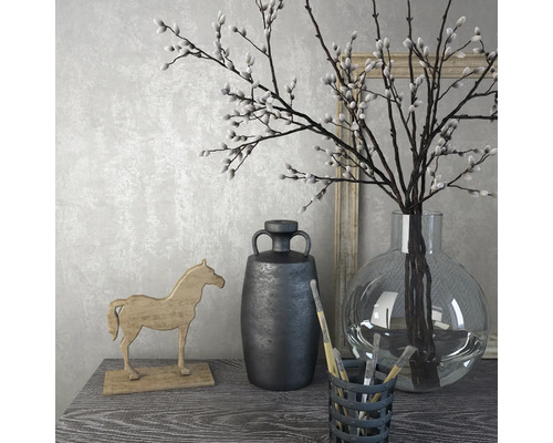 Nature morte décorative avec vase, branches, cheval en bois et cruche sur une table.