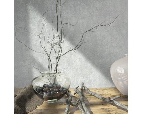Scène décorative avec un vase en verre, des branches et des billes décoratives sur une table en bois.