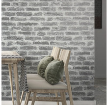 Intérieur avec un papier peint mural imitation pierre, des chaises et une table.
