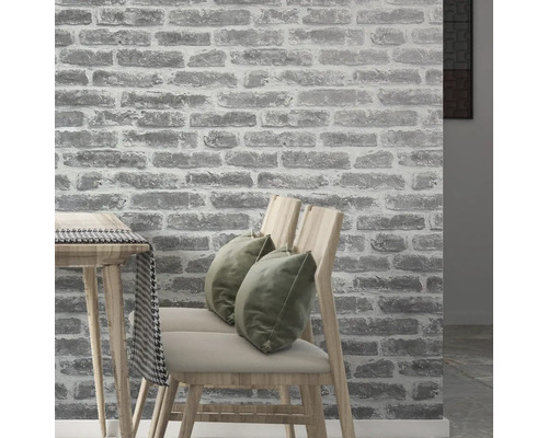 Intérieur avec un papier peint mural imitation pierre, des chaises et une table.