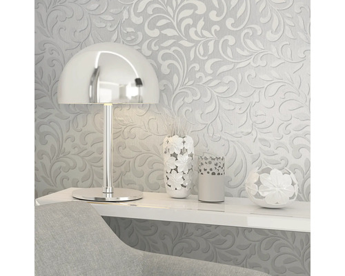 Scène décorative avec papier peint à motifs floraux, lampe et vases sur une étagère