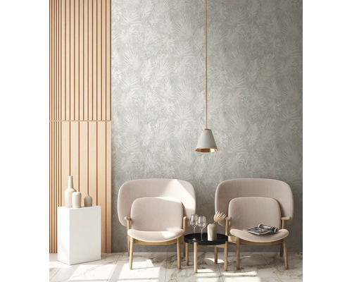 Salon avec deux fauteuils, une petite table, une suspension et un revêtement mural à motif végétal